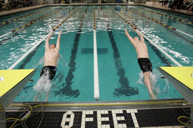 Jack Scafuri, 12, of Waukee, left, and Alek Martin, 13, of Ankeny, take off at the start of the 50 backstroke at the Ankeny YMCA in 2011.
