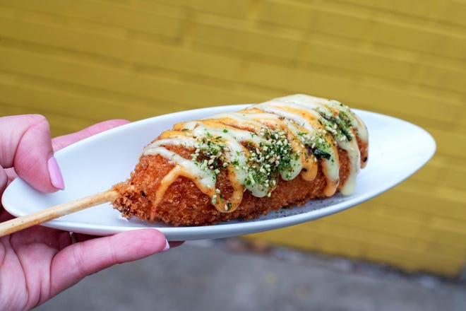 A Poke Burri corn dog with a filling of rice, seaweed and crab salad .