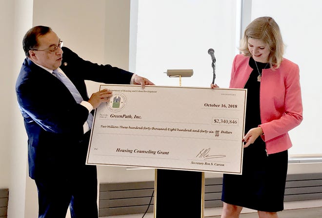 Joseph Galvan, HUD Midwest regional administrator, presents a check for $2.3 million to Kristen Holt, president and CEO of GreenPath. 