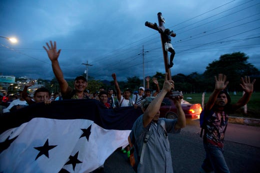 A Honduran migrant holds up a replica of the Black Christ of Esquipulas as a caravan of migrants making their way to the U.S. arrives to Esquipulas, Guatemala, Monday, Oct. 15, 2018. The Guatemalan police blocked the road of the caravan for several hours before allowing the migrants to continue on their way. (AP Photo/Moises Castillo) ORG XMIT: XMC137