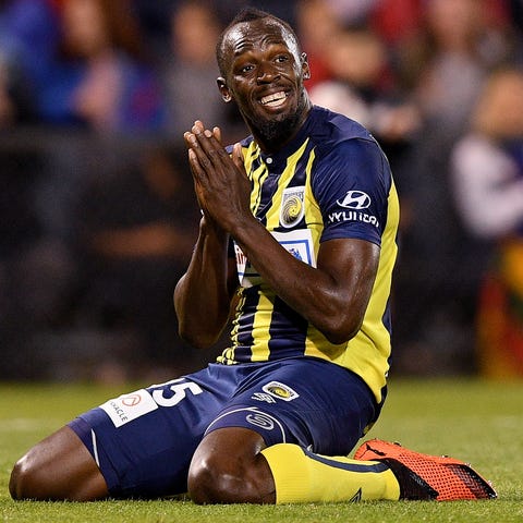 Usain Bolt reacts after missing a shot at goal...