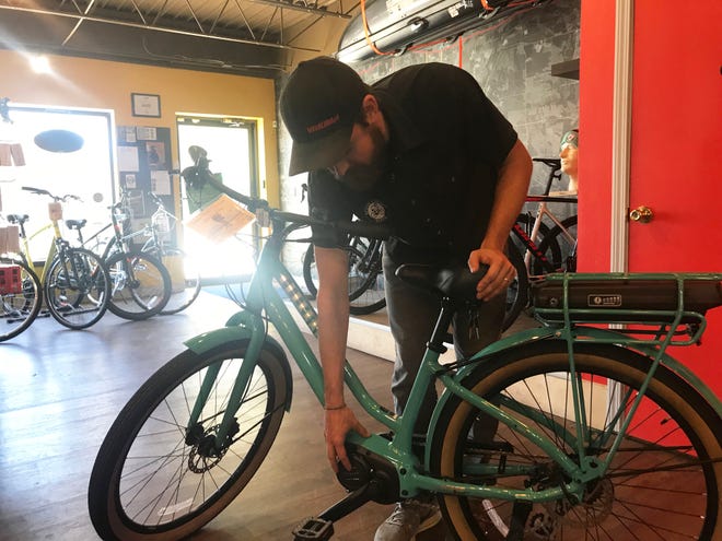 Spoke-N-Sport manager Peter Oien showcases an pedal-assisted electronic bicycle from inside the business' Minnesota Avenue store in Sioux Falls Wednesday, Oct. 17, 2018.