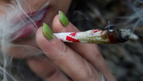 Krissy Calkins smokes a marijuana joint at a...