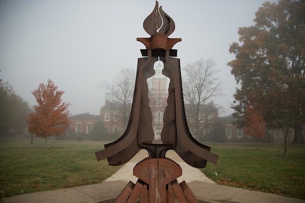 The Gateway, James Diehr's sculpture, reveals the campus' Browning Building on a foggy morning.