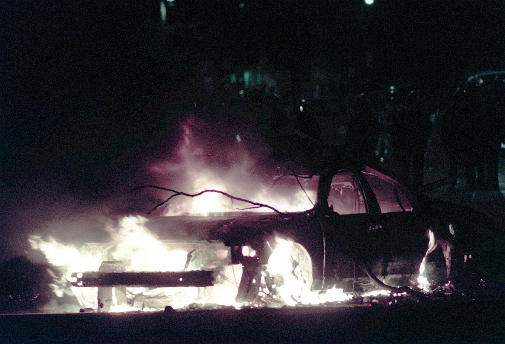 A police car burns on Bogue street in East Lansing during a riot in 1999.