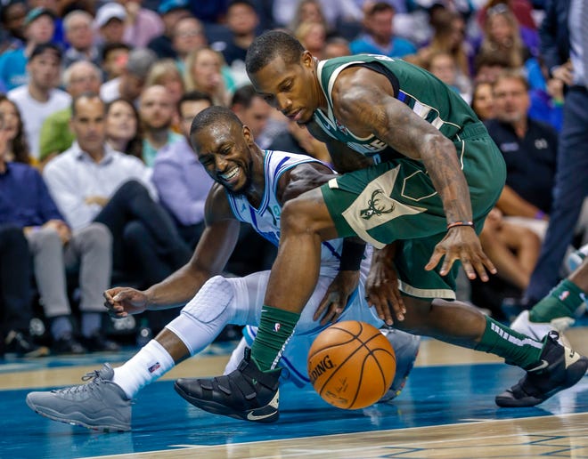 Hornets guard Kemba Walker, left, and Bucks guard Eric Bledsoe fight for a loose ball in the second half.