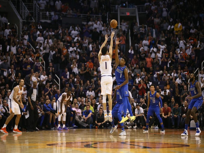 Phoenix Suns Devin Booker puts up a 3-point shot against the Dallas Mavericks during the season opener at Talking Stick Resort Arena on Oct. 17, 2018, in Phoenix, Ariz.