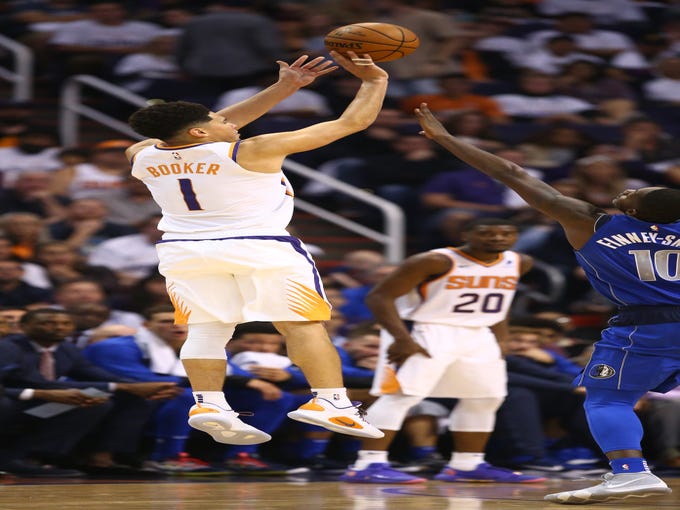 Phoenix Suns Devin Booker makes a 3-point shot against the Dallas Mavericks during the season opener at Talking Stick Resort Arena on Oct. 17, 2018, in Phoenix, Ariz.