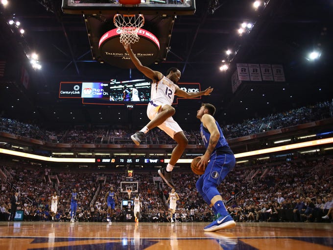 Phoenix Suns TJ Warren guards Dallas Mavericks Luka Doncic during the season opener at Talking Stick Resort Arena on Oct. 17, 2018, in Phoenix, Ariz.