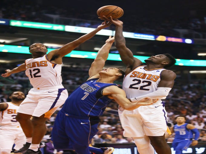 Phoenix Suns rookie center Deandre Ayton reaches for the rebound against Dallas Mavericks Dwight Powell during the season opener at Talking Stick Resort Arena on Oct. 17, 2018, in Phoenix, Ariz.