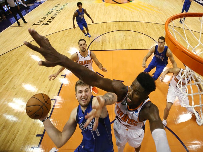 Phoenix Suns rookie center Deandre Ayton pressures the shot by Dallas Mavericks rookie Luka Doncic during the season opener at Talking Stick Resort Arena on Oct. 17, 2018, in Phoenix, Ariz.