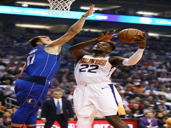 Suns rookie center Deandre Ayton scores the first basket of his NBA career against the Mavericks? Luka Doncic during Wednesday?s season opener at Talking Stick Resort Arena. Ayton scored 18 points, Devin Booker led the team with 35 points and the Suns defeated the Mavericks 121-100. Recap, 5C
 Rob Schumacher/The Republic
Phoenix Suns center Deandre Ayton scores his first basket of his NBA career against Dallas Mavericks Luka Doncic during the season opener at Talking Stick Resort Arena on Oct. 17, 2018, in Phoenix, Ariz.
