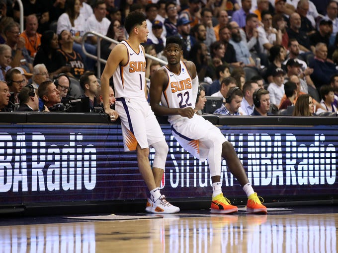 Phoenix Suns Devin Booker and Deandre Ayton prepare to check back into the game against the Dallas Mavericks during the season opener at Talking Stick Resort Arena on Oct. 17, 2018, in Phoenix, Ariz.