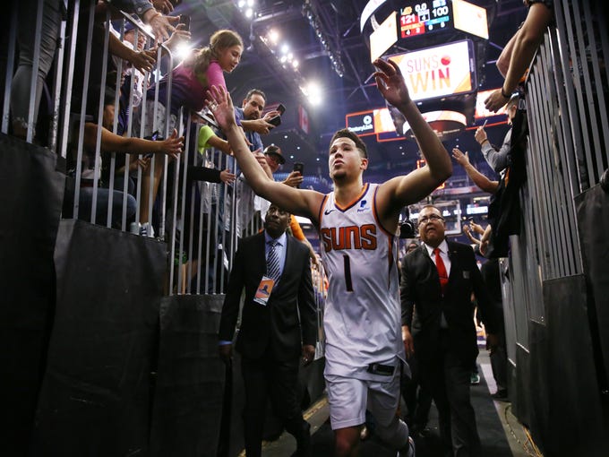 Phoenix Suns Devin Booker high-fives the fans after scoring 35-points and beating the Dallas Mavericks during the season opener at Talking Stick Resort Arena on Oct. 17, 2018, in Phoenix, Ariz.