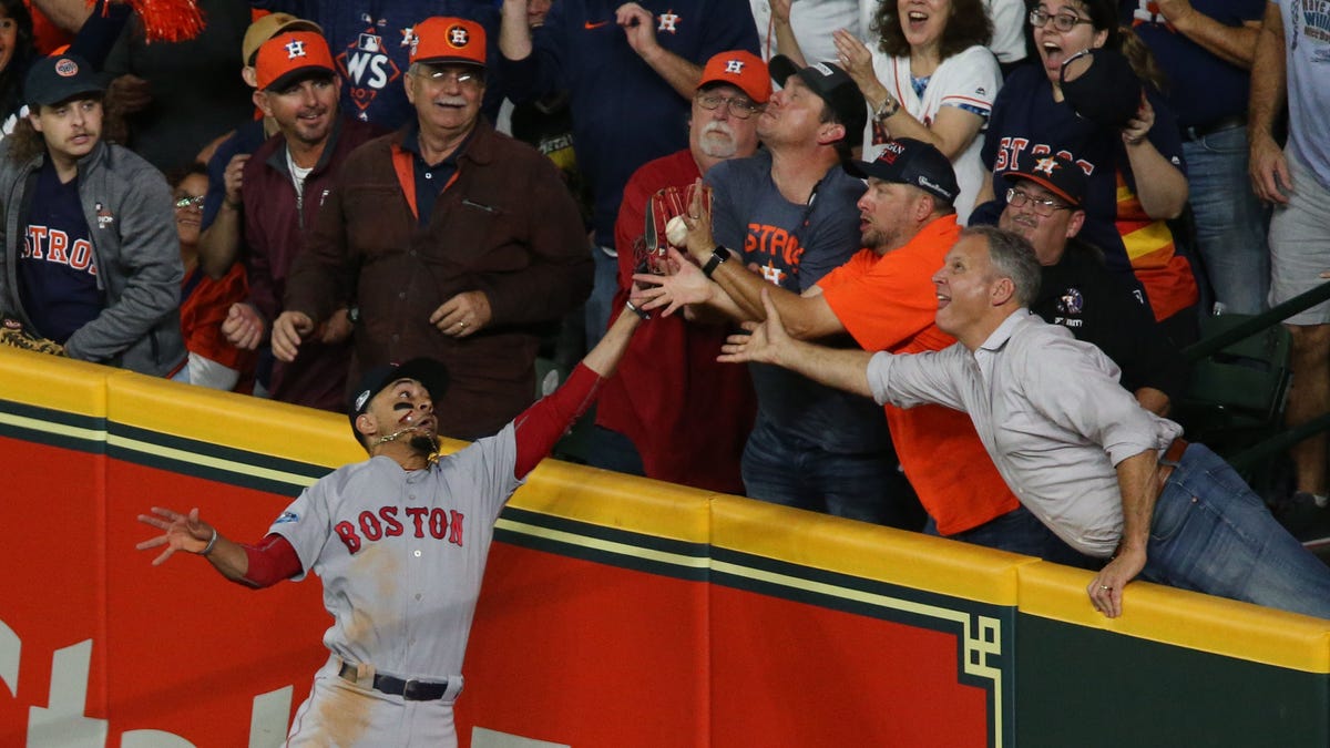 Red Sox right fielder Mookie Betts tries to catch a ball hit by Astros second basman Jose Altuve during the first inning of Game 4 of the ALCS. The play was ruled fan interference.