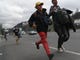 Migrants run to board a bus as part of a caravan of immigrants en route to the Mexican border in Guatemala City, Guatemala. Oct. 18, 2018. 