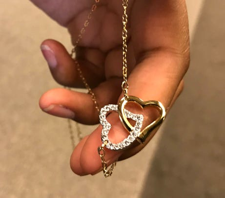 C'Nai Lange, 17, of Macomb Township holds a double heart necklace that she bought for her mom, Kathy Lange. She gave her mom the necklace during the adoption proceeding in Macomb County Circuit Court on Oct. 19, 2018.