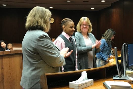 Lisa Lange, left, and Kathy Lange, both of Macomb Township, clap for their daughter, C'Nai Lange, 17, who they adopted Oct. 19, 2018 in Macomb County Circuit Court.