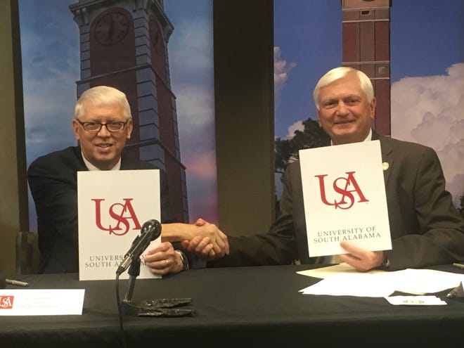 University of South Alabama President Tony Waldrop, left, and Pensacola State College President Ed Meadows shake hands after signing the 'Pathway USA' articulation agreement Friday at the PSC campus.