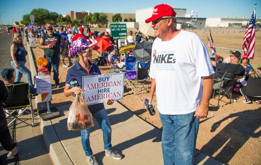Sheridan Beaulieu of Florence and Bryan Harmon of Prescott wait in line to enter the International Air Response Hangar at Phoenix-Mesa Gateway Airport Oct. 19, 2018. President Donald Trump will appear Friday evening for a rally supporting Senate candidate Rep. Martha McSally.