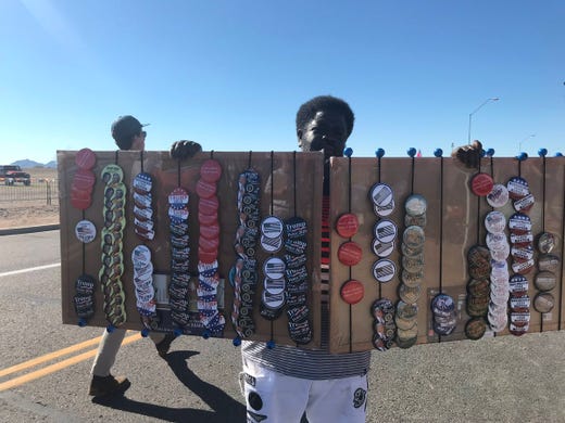 Vendors sell merchandise celebrating President Donald Trump, who is set to speak at a rally in Mesa, on Oct. 19, 2018. Many of them follow Trump from rally to rally, visiting dozens of cities each year.