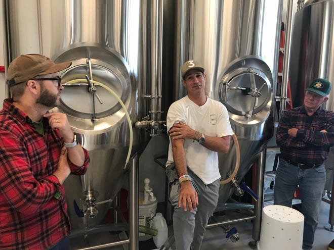 Bryan Selders (left), Sam Calagione (middle) and John Carter (right) discuss the apple cider doughtnut inspired beer Dogfish Head Craft Brewery and Dewey Beer Co. are creating in Rehoboth Beach on Oct. 18, 2018.