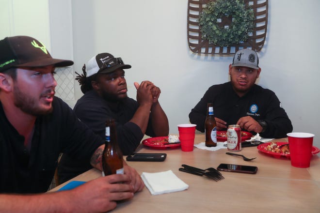 Dalton Garza, Debo McMillian and Jose Peña, apprentice linemen, eat dinner in the home of David and Ashley Bentley in the Ox Bottom Crest subdivision in Tallahassee, Fla. Thursday, Oct. 18, 2018.