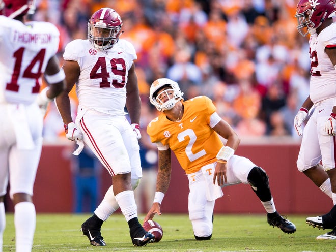 Tennessee quarterback Jarrett Guarantano (2) grimaces as he gets up after being sacked by Alabama defensive lineman Isaiah Buggs (49) during the Tennessee Volunteers' game against Alabama in Neyland Stadium on Saturday, October 20, 2018.