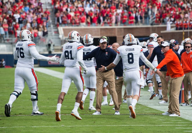 Auburn head coach Gus Malzahn high fives his team as they come off the field after a touchdown at Vaught-Hemingway Stadium in Oxford, Miss., on Saturday, Oct. 20, 2018.
