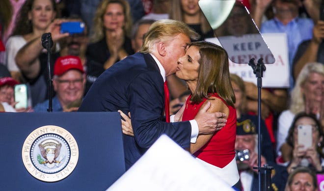President Donald Trump and Rep. Martha McSally kiss on the cheek at Phoenix-Mesa Gateway Airpor on Oct. 19, 2018, during a rally for McSally.