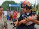 A Guatemalan firefighter carries an ailing baby, as an Honduran migrant caravan heading to the US, reaches the Guatemala-Mexico international bridge in Tecun Uman, Guatemala on Oct. 19, 2018. 