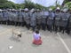 A Honduran migrant girl kneels in front of a police checkpoint at the Agua Caliente border crossing in Ocotepeque, Honduras on Oct. 19, 2018. Honduran authorities intensified immigration control measures at the Agua Caliente point, bordering Guatemala, to prevent hundreds of Hondurans seeking to reach the USA from crossing into the neighboring country. 