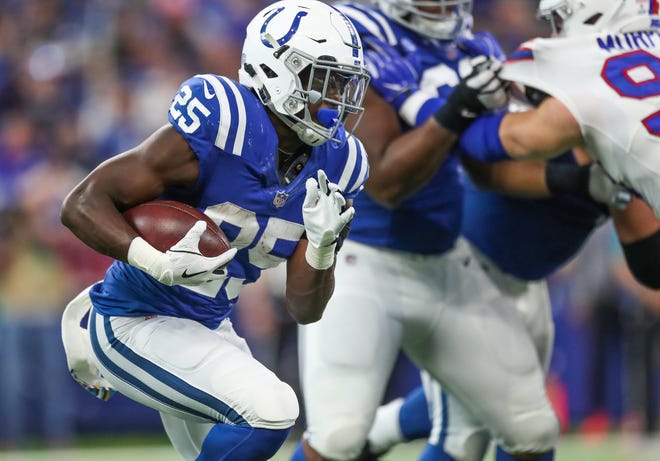 Indianapolis Colts running back Marlon Mack (25) makes his way through the defensive line of the Buffalo Bills at Lucas Oil Stadium on Sunday, Oct. 21, 2018.
