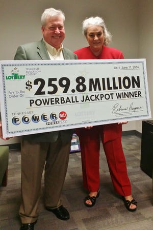 Roy Cockrum of Knoxville accepts the Powerball jackpot winnings (pre-taxed) from Rebecca Hargrove of the Tennessee Education Lottery. Scammers have been using his name and foundation since he won the prize in 2014.