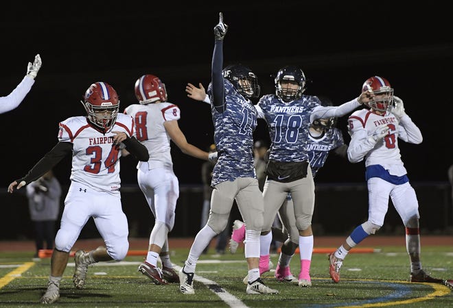 Pittsford kicker Kyle Hennessey, pointing, celebrates his game-winning extra point with holder Tyler Love during after Pittsford defeated Fairport 28-27 in overtime Saturday night to advance to the semifinals against Aquinas.