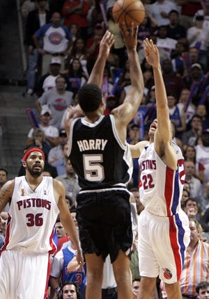 San Antonio Spurs forward Robert Horry shoots the winning 3-point shot over Detroit Pistons' Tayshaun Prince (22) and Rasheed Wallace (36) during overtime in Game 5 of the NBA Finals in Auburn Hills, June 19, 2005. The Spurs won 96-95 to take a 3-2 series lead.