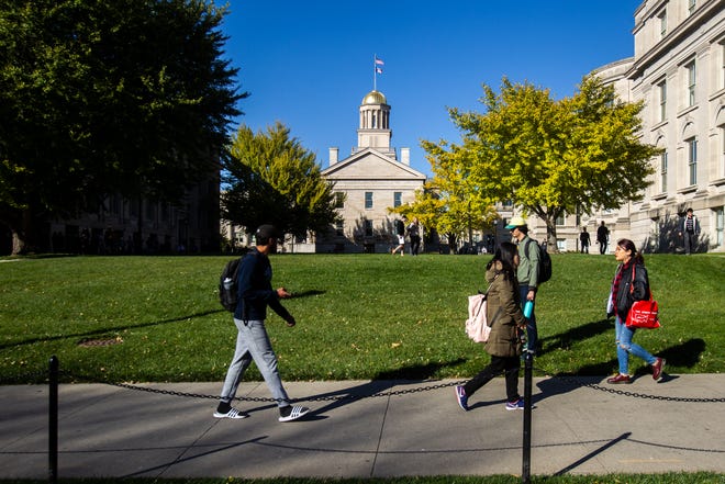 Students walk along Washington Street past the Old Capitol on Monday, Oct. 22, 2018, on the University of Iowa campus in Iowa City.
