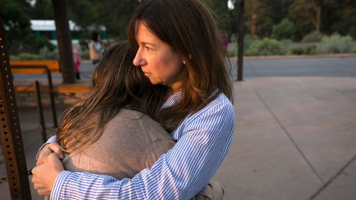 Laura Trujillo of Cincinnati, Ohio, and her daughter, Lucy Faherty, 12, hug while waiting for a Grand Canyon National Park shuttle bus to take them to the Trailview Overlook on the south rim of the Grand Canyon in Grand Canyon National Park.