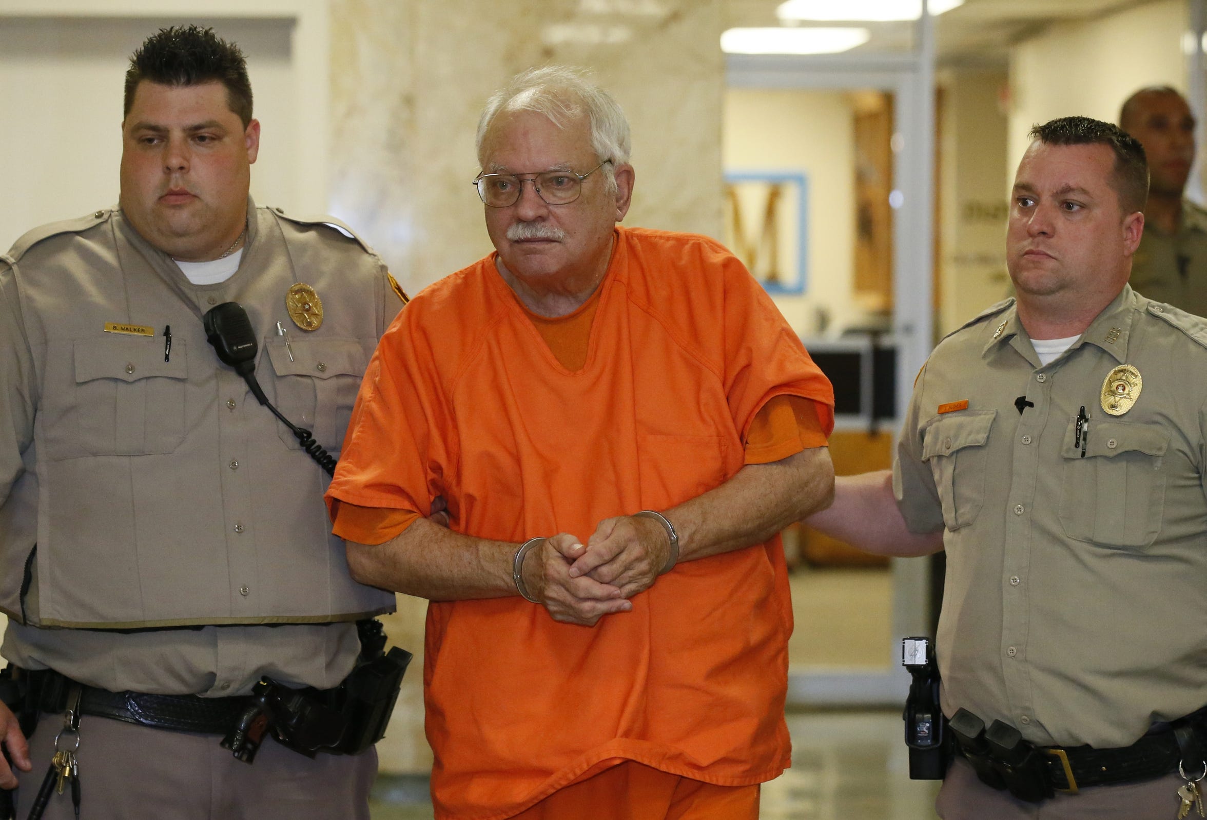 Robert Bates, a former Oklahoma volunteer sheriff's deputy who said he mistook his handgun for his stun gun when he fatally shot an unarmed suspect last year, is escorted from the courtroom following his sentencing at the courthouse in Tulsa, Okla., Tuesday, May 31, 2016. Bates, who was convicted of second-degree manslaughter, was sentenced to four years. (AP Photo/Sue Ogrocki)