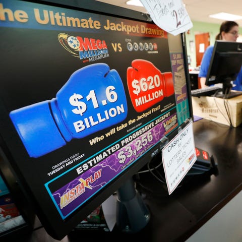 A customer buys a Mega Millions lottery ticket at...