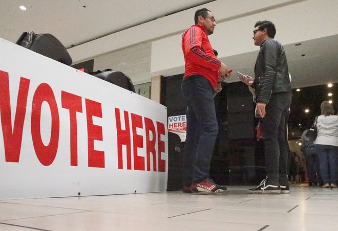 Carlos Lopez, center, went to the early polling station inside Bassett Place to cast his ballot in Oct. 2018.
