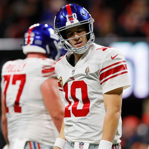 Eli Manning reacts after being sacked by the...