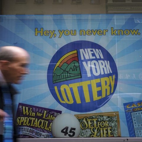 People walk past the New York Lottery Customer Ser