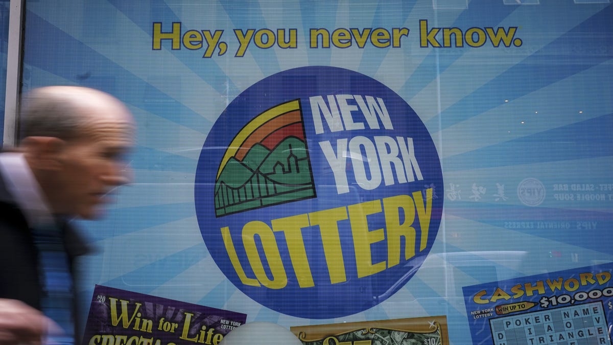People walk past the New York Lottery Customer Service Center in Lower Manhattan, October 23, 2018 in New York City. The $1.6 billion Mega Millions prize to be drawn Tuesday night is set to be the largest lottery prize in U.S. history.