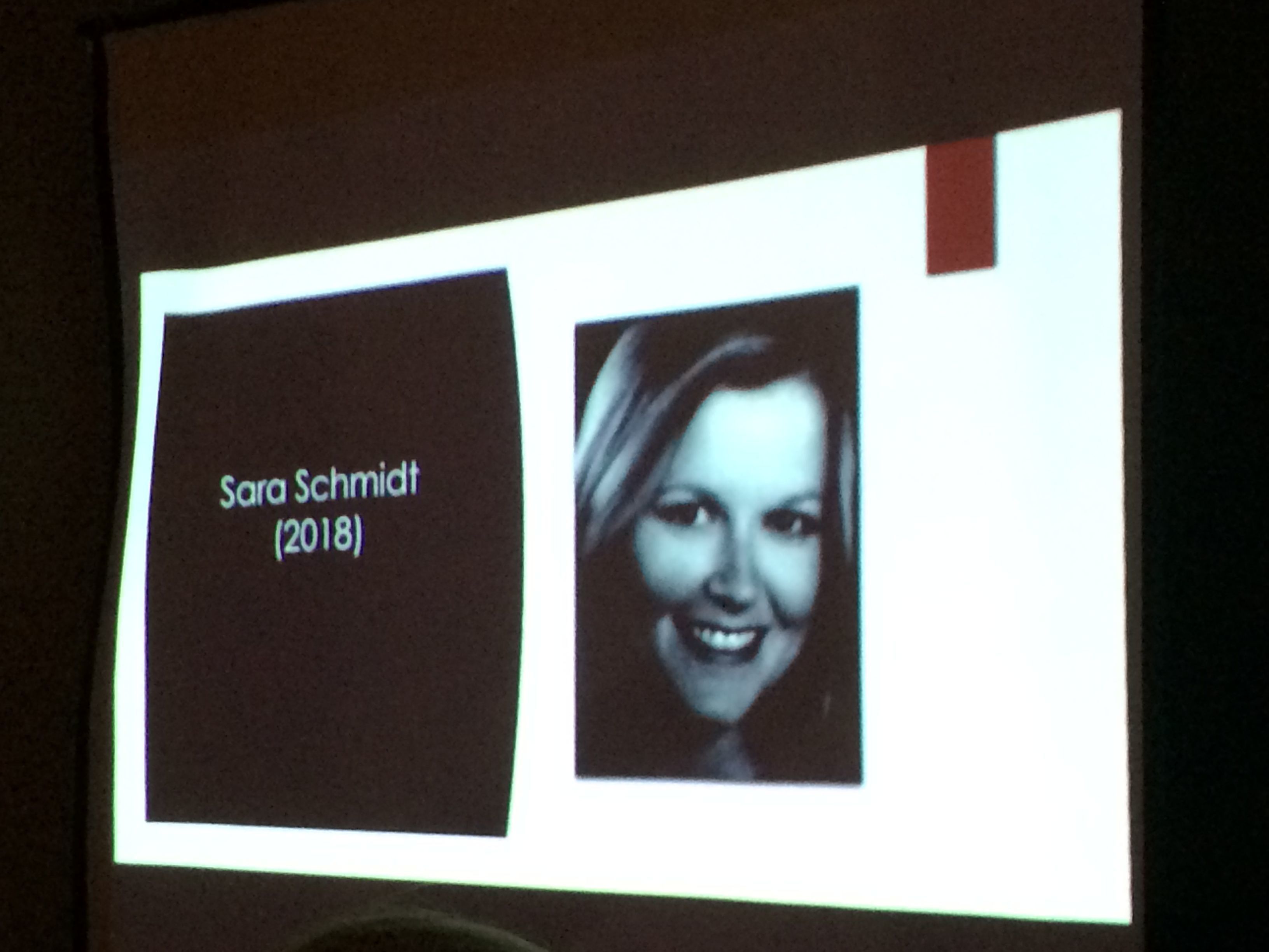 A slideshow shows an image of Sara Schmidt at a vigil. Schmidt was shot killed by her husband in 2018.