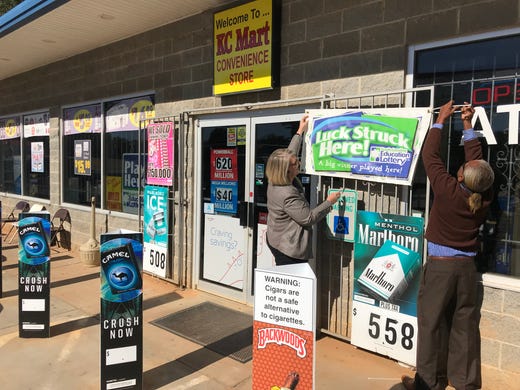 Suzanne Slacas, left, and Terry Gist with the SC Lottery hang a banner at the KC Mart in Simpsonville. Lottery officials said someone in South Carolina won the record $1.6 billion Mega Millions jackpot, and by 11 a.m. Wednesday, announced it was the KC Mart #7 at 303 Lee Vaughn Road in Simpsonville.