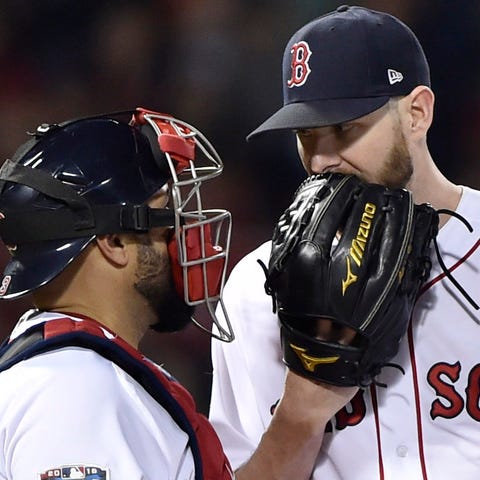 Red Sox pitcher Chris Sale (middle) meets with...