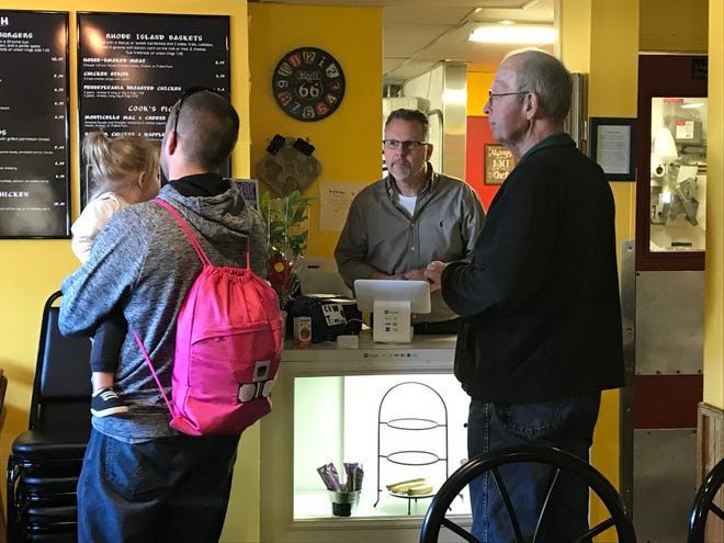 Co-owner Mark Taylor takes orders from customers at Fidler's on the Grand in Lansing.