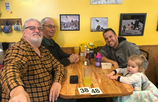 Customers Fred Baer, left, Tim Crawford, Tyler Bergstrom and Amelia Bergstrom wait for their food at Fidler's on the Grand in Lansing.