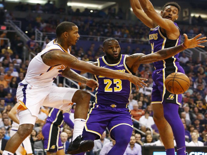 Phoenix Suns' Trevor Ariza passes the ball with pressure from Los Angeles Lakers' LeBron James in the first half during a game on Oct. 24 at Talking Stick Resort Arena.